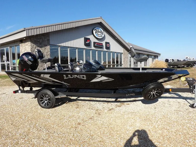 Slide: The Image of Lund 1975 Renegade SS 2025 model boat parked outside dealership on sunny day. - 49