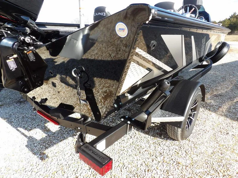 Slide: The Image of 2025 Lund 1975 Renegade SS boat on trailer, rear view, black finish, outdoor setting. - 7