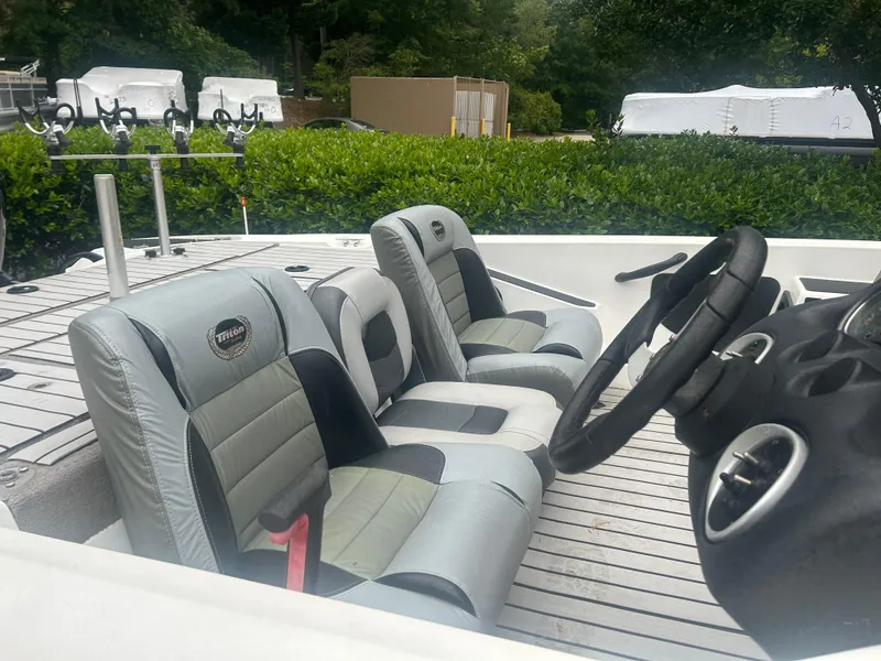 Slide: The Image of 2009 Triton 18 Explorer boat interior with gray seating and steering wheel. - 5