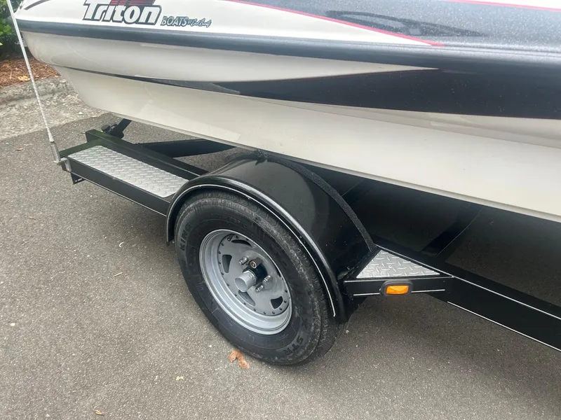 Slide: The Image of 2009 Triton 18 Explorer boat on trailer, close-up of wheel and hull design. - 8