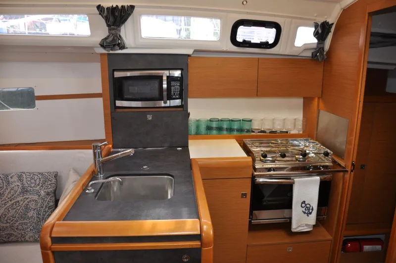 Slide: The Image of Interior of 2016 Jeanneau Sun Odyssey 349 yacht kitchen with sink, stove, and microwave. - 24