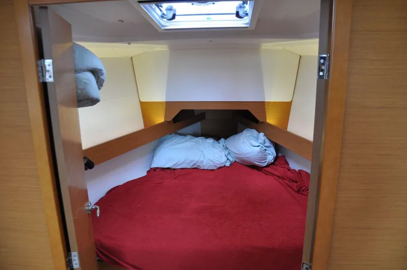 Slide: The Image of Cozy cabin interior of 2016 Jeanneau Sun Odyssey 349 sailboat with red bedding. - 27