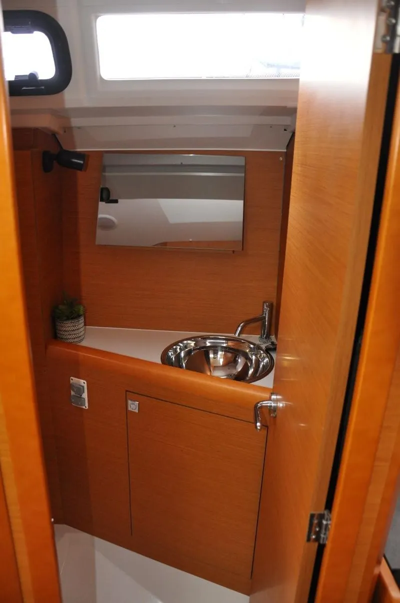 Slide: The Image of 2016 Jeanneau Sun Odyssey 349 bathroom with wooden cabinetry and stainless steel sink. - 28