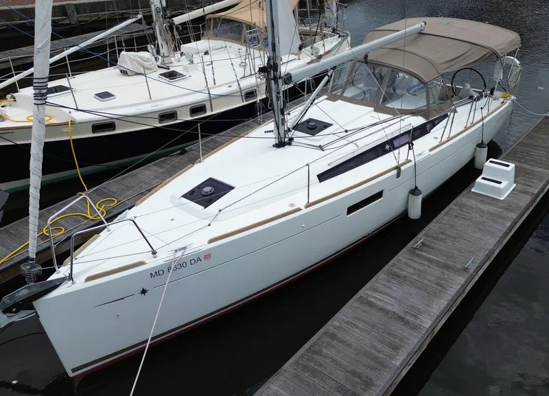 Slide: The Image of 2016 Jeanneau Sun Odyssey 349 sailboat docked at marina, featuring sleek design and canopy. - 7