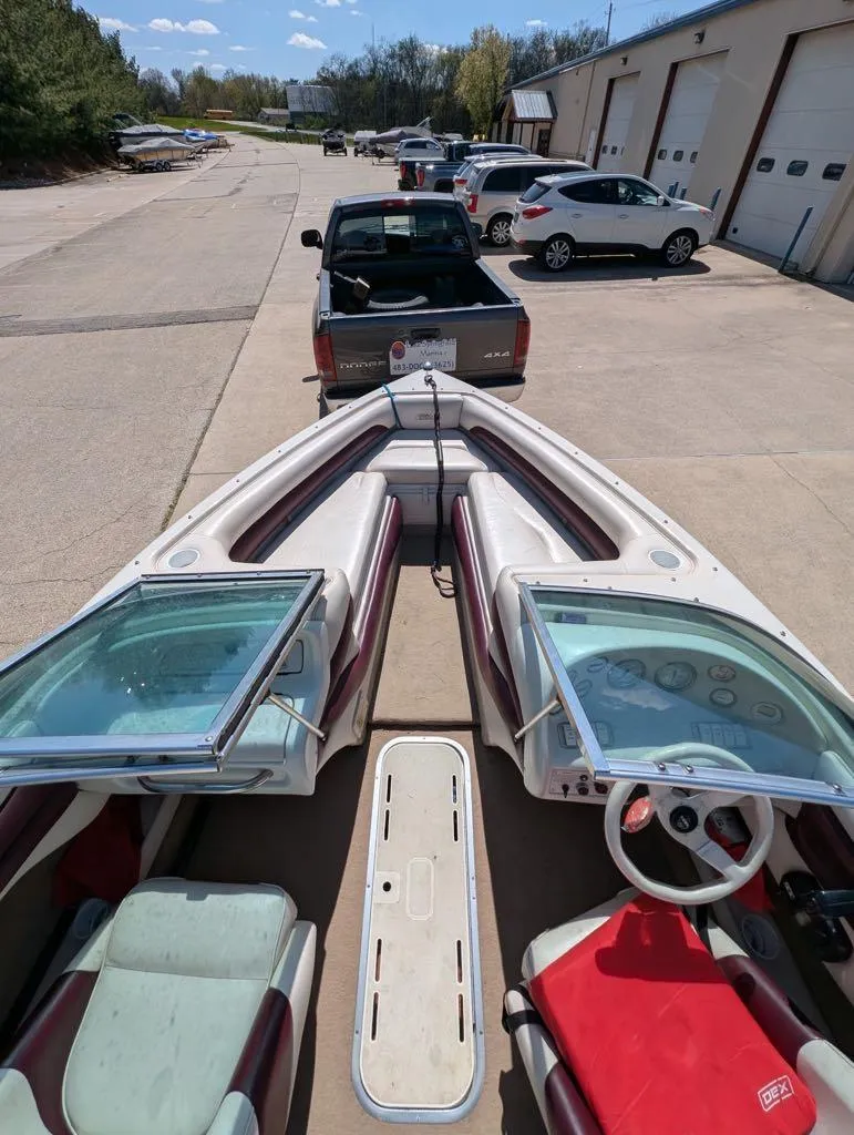Slide: The Image of 1995 Crownline 182 BR boat interior, parked on a trailer, near a garage. - 4