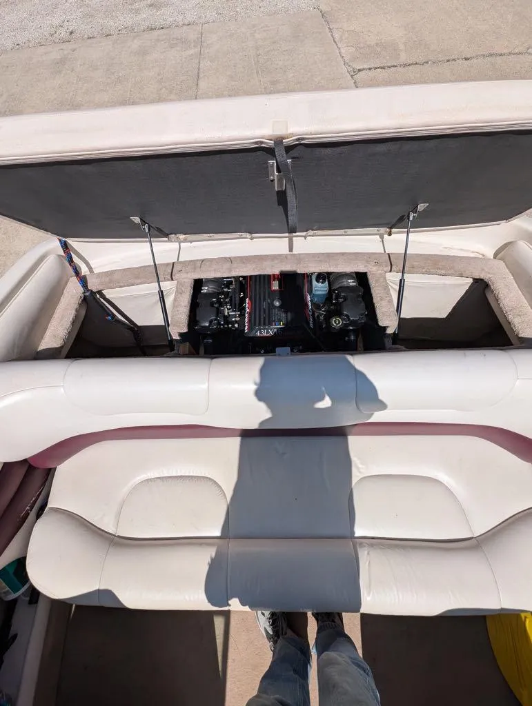 Slide: The Image of 1995 Crownline 182 BR boat engine compartment with open hatch and seating area. - 6