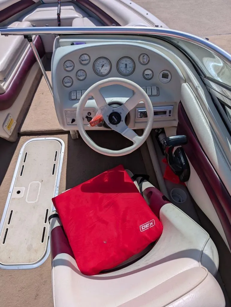 Slide: The Image of 1995 Crownline 182 BR boat dashboard with steering wheel and red seat cushion. - 8