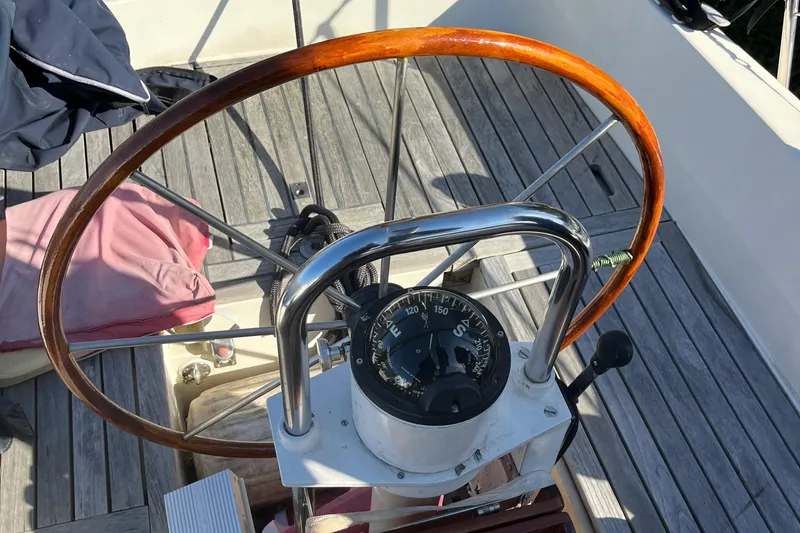Slide: The Image of Steering wheel and compass of a 1985 Contest 36S sailboat on a wooden deck. - 20