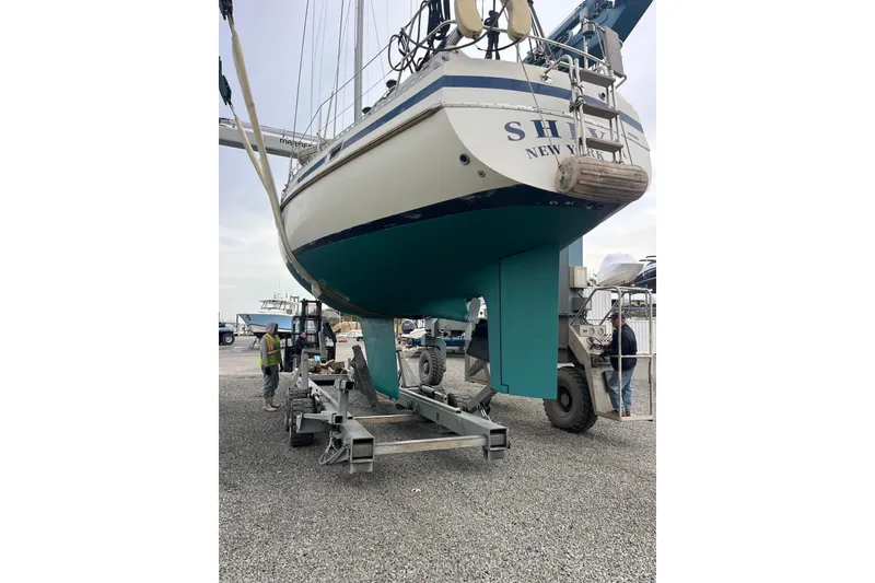 Slide: The Image of 1985 Contest 36S sailboat on trailer, New York, with workers nearby. - 27