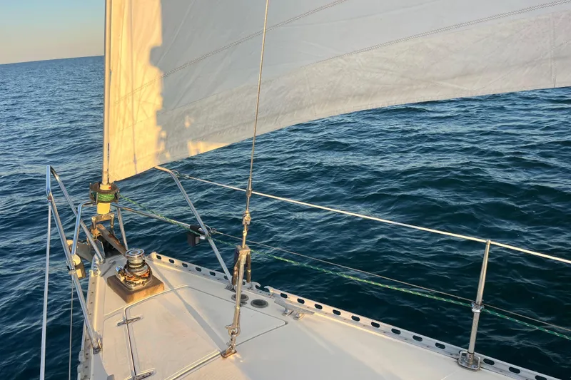 Slide: The Image of Sailing on a 1985 Contest 36S yacht with white sails over blue ocean waters. - 28