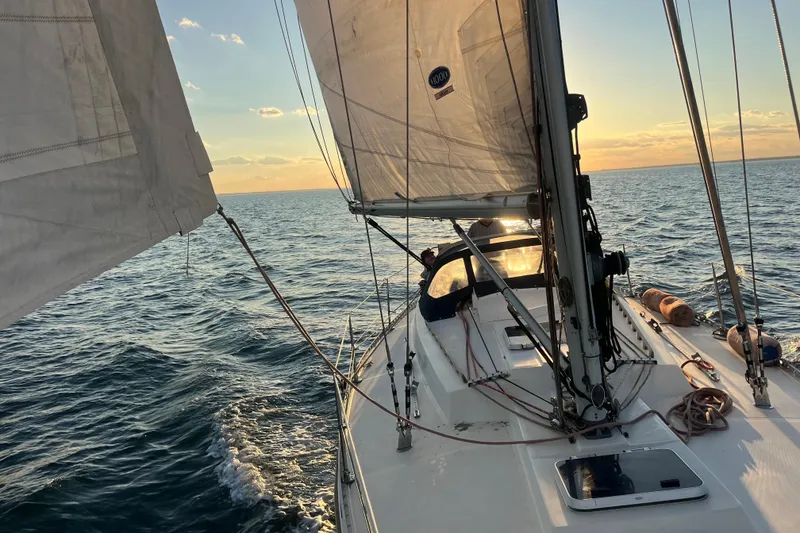 Slide: The Image of Sailing on a 1985 Contest 36S yacht at sunset over calm ocean waters. - 29