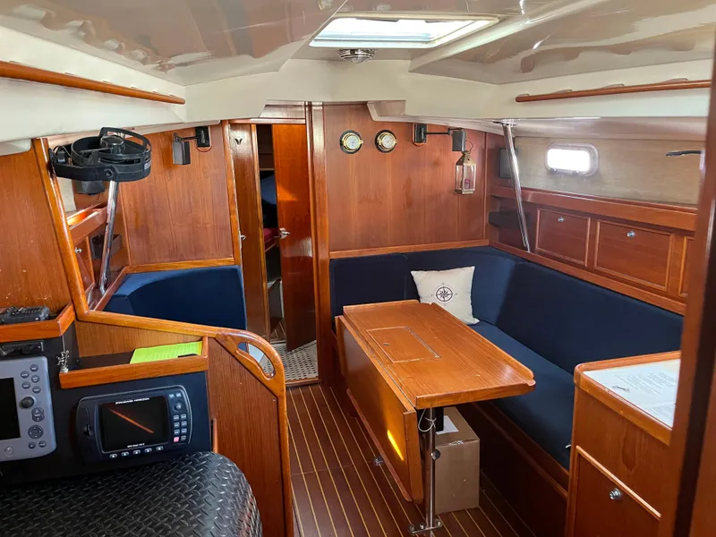 Slide: The Image of 1985 Contest 36S yacht interior with wooden finish, blue seating, and navigation equipment. - 4