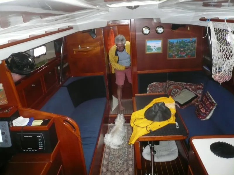 Slide: The Image of Interior of 1985 Contest 36S sailboat with person and dog, featuring wooden furnishings and nautical decor. - 5