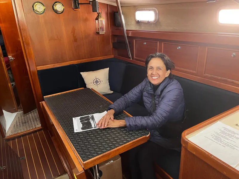 Slide: The Image of Woman smiling inside 1985 Contest 36S sailboat cabin, seated at wooden table. - 6