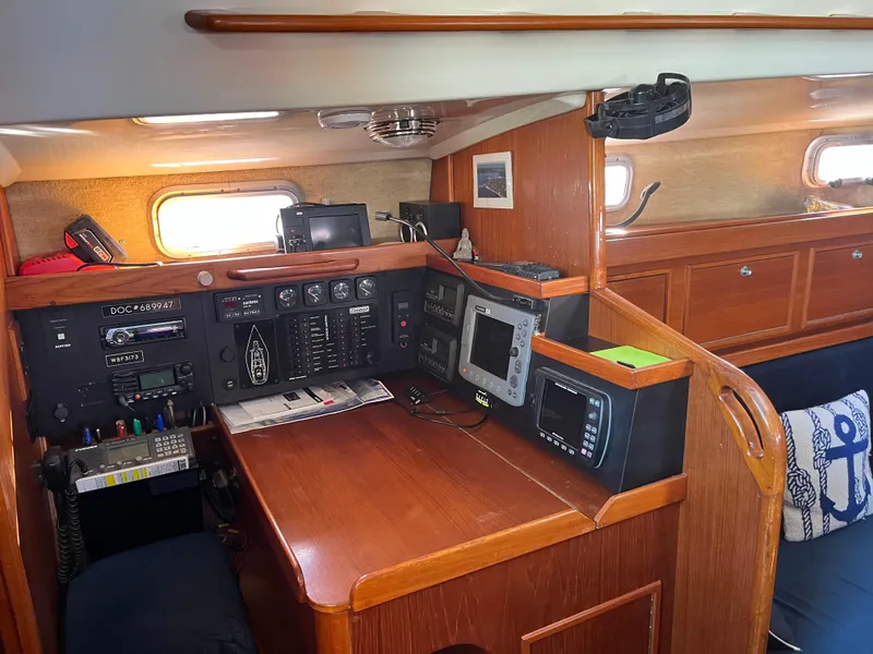 Slide: The Image of Navigation station inside 1985 Contest 36S sailboat, featuring control panels and wooden cabinetry. - 7