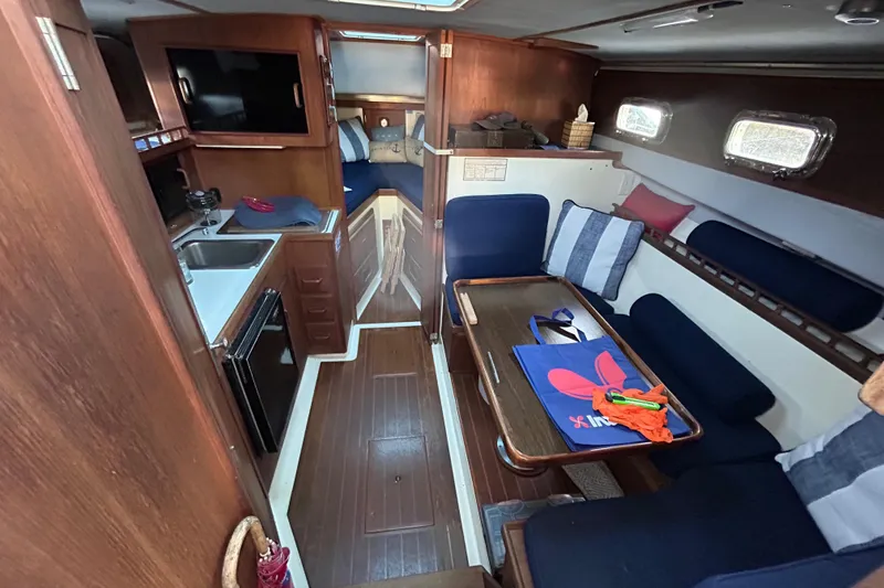 Slide: The Image of Interior of 1989 Fortier F-30 Hardtop boat with wood finish and cozy seating area. - 2