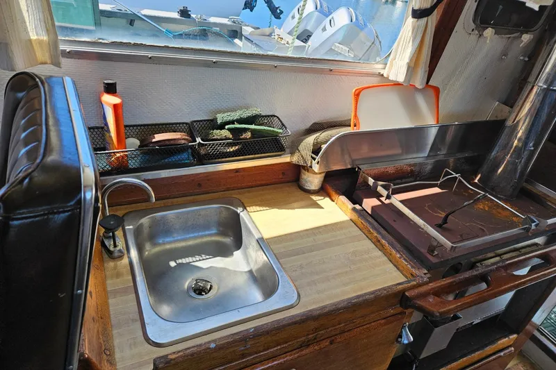 Slide: The Image of 1975 Trawler Monterey Diesel Cruiser kitchen with sink, stove, and window view. - 12