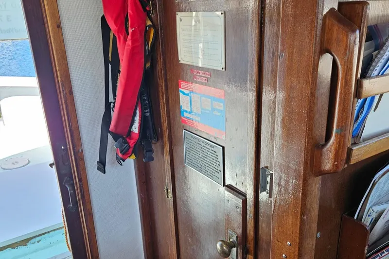 Slide: The Image of 1975 Monterey Diesel Cruiser interior with wooden door, safety equipment, and informational plaques. - 13