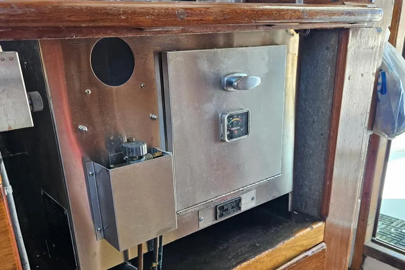 Slide: The Image of 1975 Trawler Monterey Diesel Cruiser interior with metal control panel and wooden trim. - 23