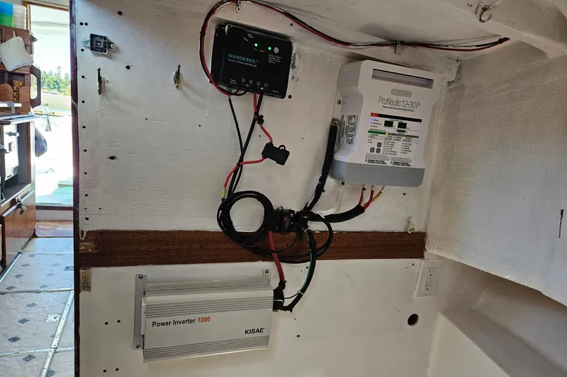 Slide: The Image of Electrical setup inside a 1975 Trawler Monterey Diesel Cruiser, featuring a power inverter and wiring. - 25