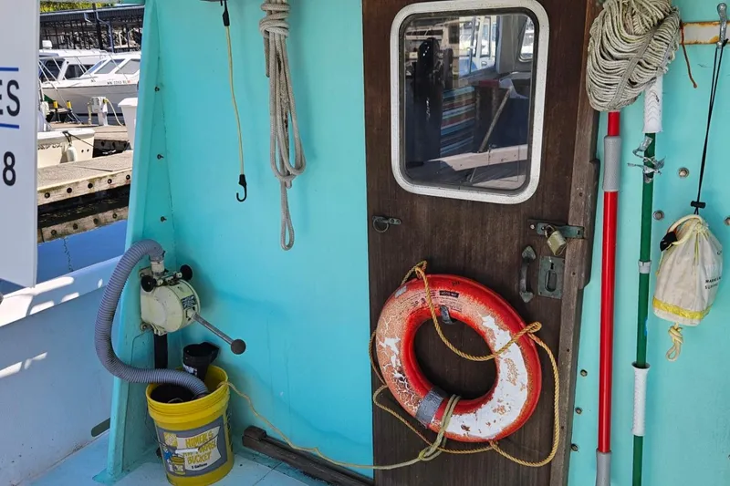 Slide: The Image of 1975 Monterey Diesel Cruiser trawler deck with life preserver and nautical equipment. - 26