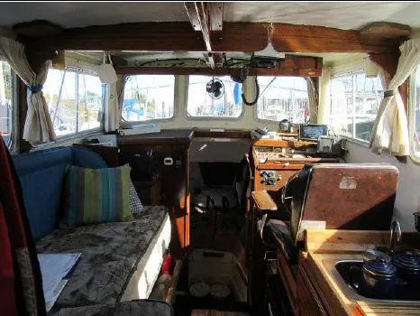 Slide: The Image of 1975 Monterey Diesel Cruiser trawler interior with cozy seating, wooden accents, and nautical equipment. - 5