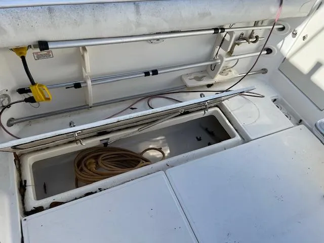 Slide: The Image of 2008 Boston Whaler 305 Conquest deck with open storage compartment and coiled rope. - 12