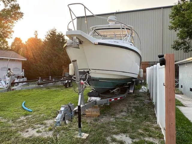 Slide: The Image of 2008 Boston Whaler 305 Conquest boat on trailer in yard at sunset. - 2