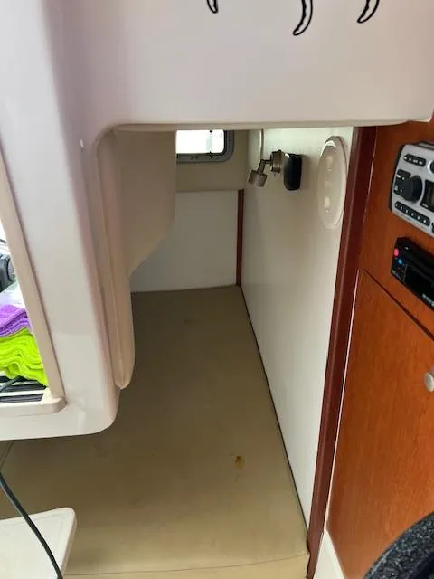 Slide: The Image of 2008 Boston Whaler 305 Conquest cabin interior with wood accents and compact design. - 21