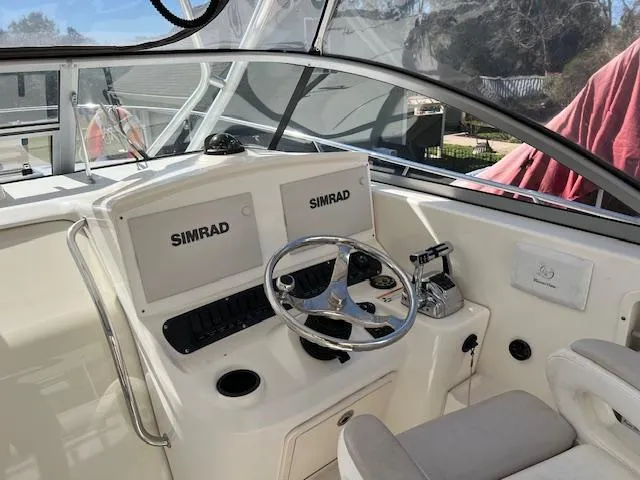 Slide: The Image of 2008 Boston Whaler 305 Conquest helm with dual Simrad displays and steering wheel. - 7