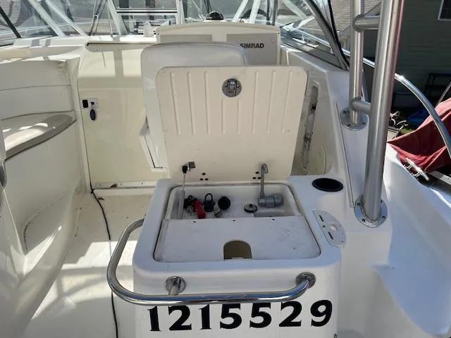 Slide: The Image of 2008 Boston Whaler 305 Conquest boat interior with open storage compartment and visible equipment. - 9