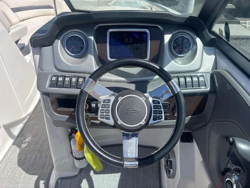Slide: The Image of 2017 Chaparral 264 Sunesta Surf boat dashboard with steering wheel and control panel. - 13