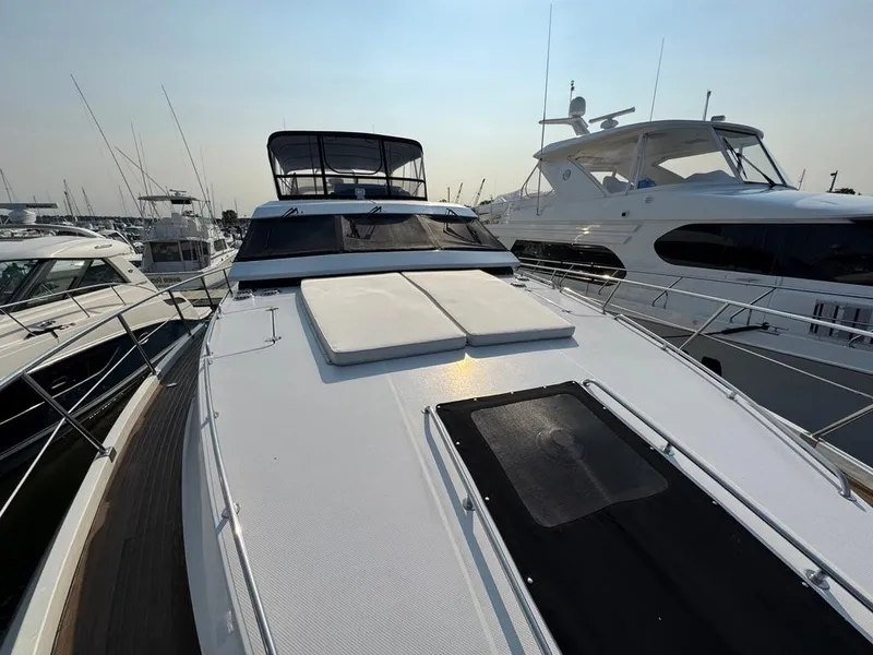 Slide: The Image of 1989 Birchwood 62 Cockpit Motor Yacht docked among other luxury boats. - 15