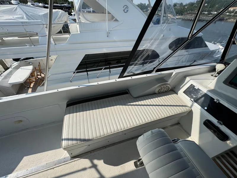 Slide: The Image of 1989 Birchwood 62 Cockpit Motor Yacht interior with cushioned seating and sleek design. - 16