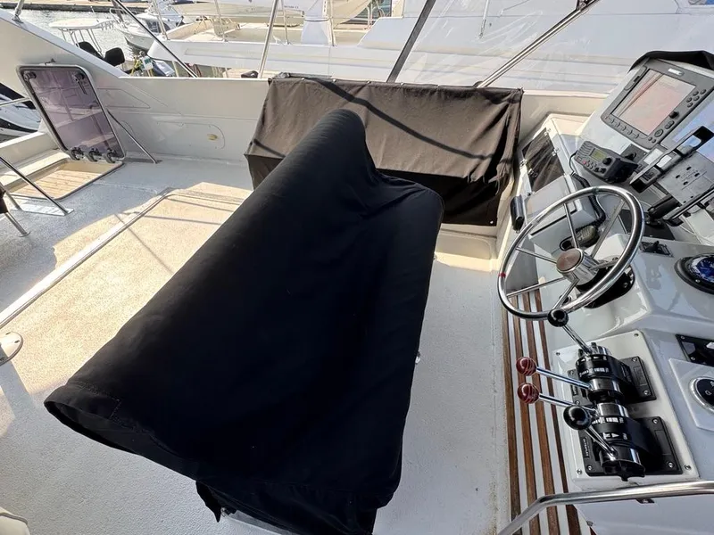 Slide: The Image of 1989 Birchwood 62 Cockpit Motor Yacht helm with covered seating and navigation controls. - 18