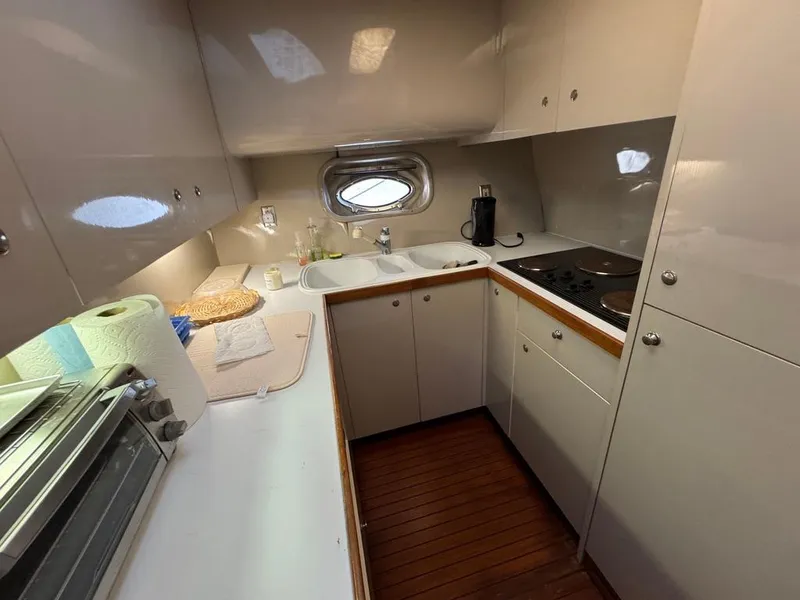Slide: The Image of Compact kitchen in 1989 Birchwood 62 Cockpit Motor Yacht with modern amenities and wooden flooring. - 25