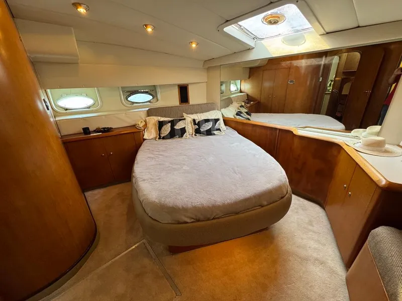 Slide: The Image of Luxurious bedroom interior of 1989 Birchwood 62 Cockpit Motor Yacht with elegant wood finishes. - 28