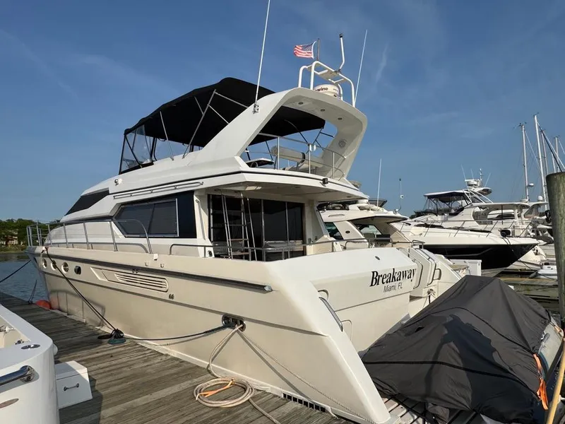 Slide: The Image of 1989 Birchwood 62 Cockpit Motor Yacht docked, featuring sleek design and spacious upper deck. - 3