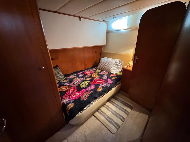 Slide: The Image of Cozy cabin interior of 1989 Birchwood 62 Cockpit Motor Yacht with colorful bedding. - 30