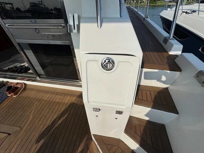Slide: The Image of 1989 Birchwood 62 Cockpit Motor Yacht deck with wooden flooring and stairs. - 31