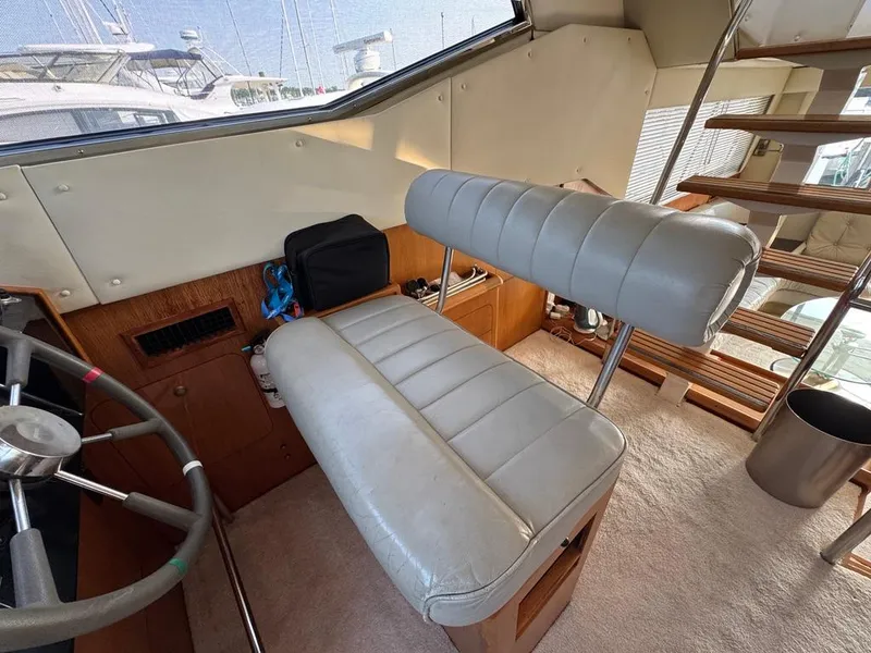 Slide: The Image of 1989 Birchwood 62 Cockpit Motor Yacht interior with helm seat and wooden stairs. - 32