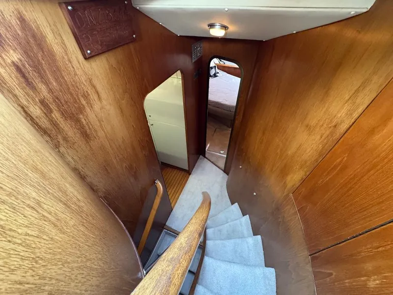 Slide: The Image of Staircase inside 1989 Birchwood 62 Cockpit Motor Yacht with wooden paneling and carpeted steps. - 33