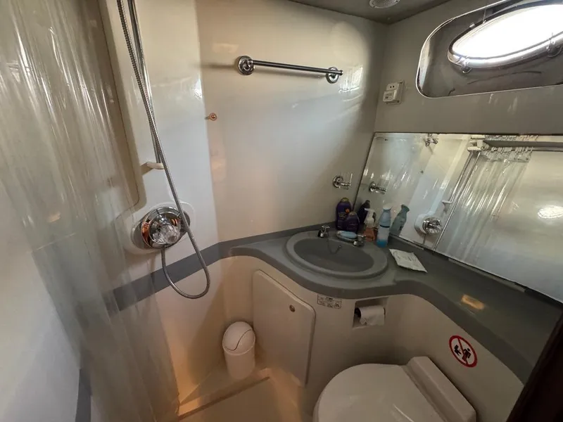 Slide: The Image of Bathroom in 1989 Birchwood 62 Cockpit Motor Yacht, featuring shower, sink, and toilet. - 34