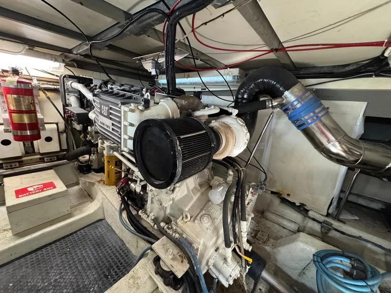 Slide: The Image of Engine room of 1989 Birchwood 62 Cockpit Motor Yacht, featuring CAT engine and fire extinguisher. - 43