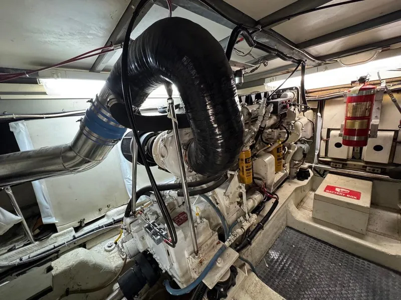 Slide: The Image of Engine room of a 1989 Birchwood 62 Cockpit Motor Yacht, featuring complex machinery and piping. - 44