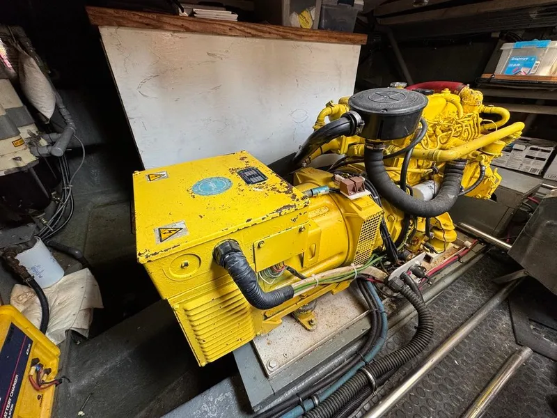 Slide: The Image of Engine room of a 1989 Birchwood 62 Cockpit Motor Yacht with yellow machinery. - 45