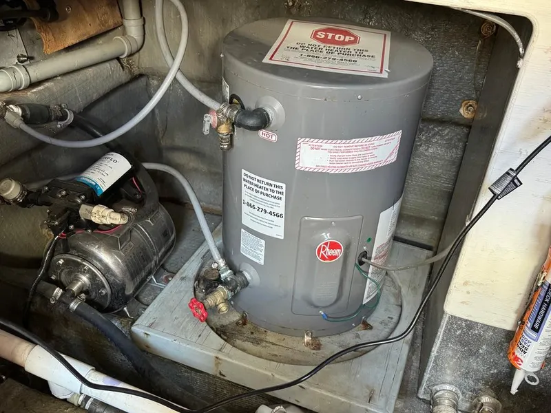 Slide: The Image of Water heater and pump system in 1989 Birchwood 62 Cockpit Motor Yacht engine room. - 46