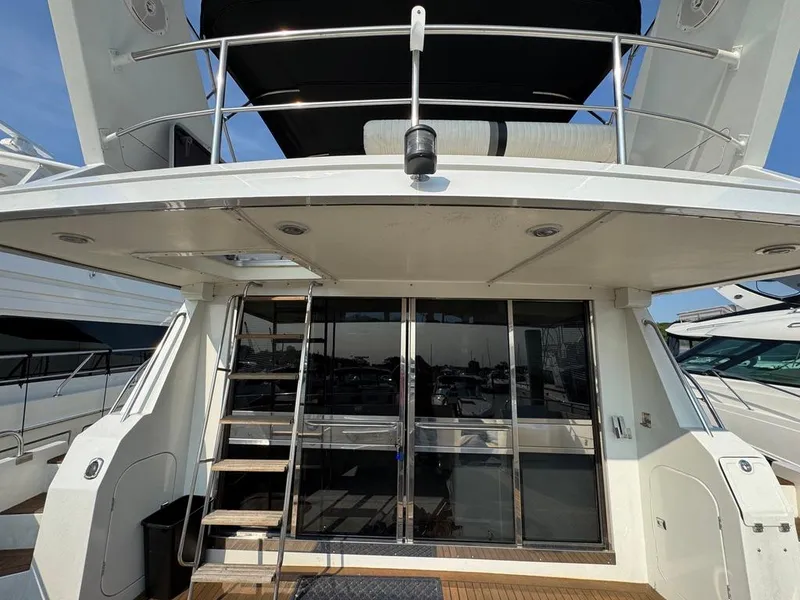 Slide: The Image of 1989 Birchwood 62 Cockpit Motor Yacht with sliding glass doors and upper deck railing. - 5