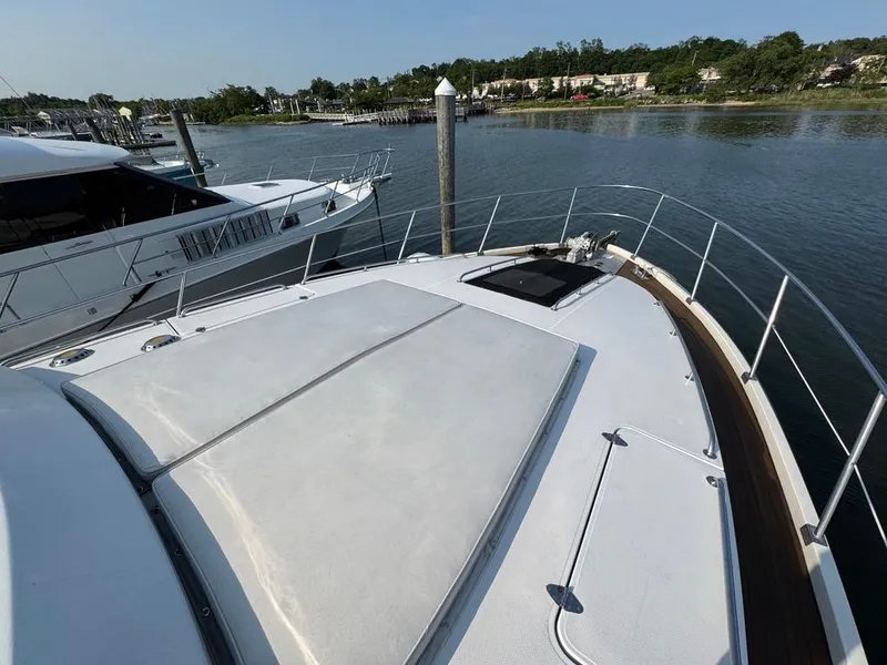 Slide: The Image of 1989 Birchwood 62 Cockpit Motor Yacht docked by a serene waterfront. - 8
