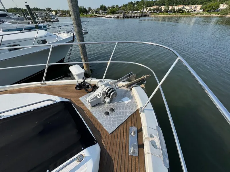 Slide: The Image of 1989 Birchwood 62 Cockpit Motor Yacht bow with anchor system, docked by calm waters. - 9